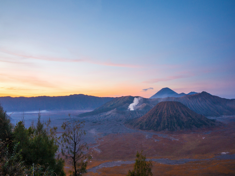 Sunrise dari tepi Kaldera Bromo dalam kawasan Taman Nasional Bromo Tengger Semeru, Probolinggo. Tampak Gunung Semeru di kejauhan.