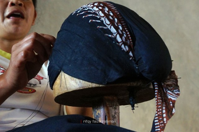 Blangkon yang sedang dijahit di atas plonco. Tampak lekuk mondholan sebagai ciri khas blangkon Yoyyakarta