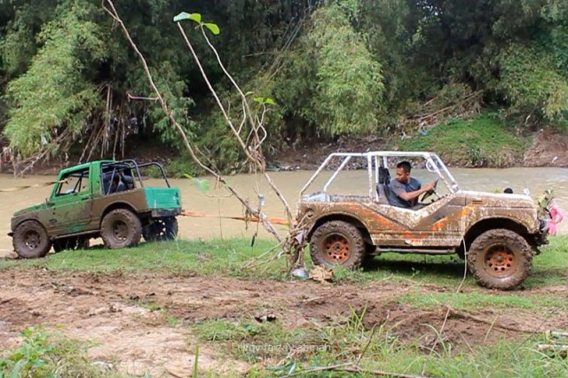 Arif (jip putih) sedang menarik jip hijau yang dikemudikan Fian. Di sisi yang berlawanan, Taufiq di jip merah juga membantu menarik bersamaan.