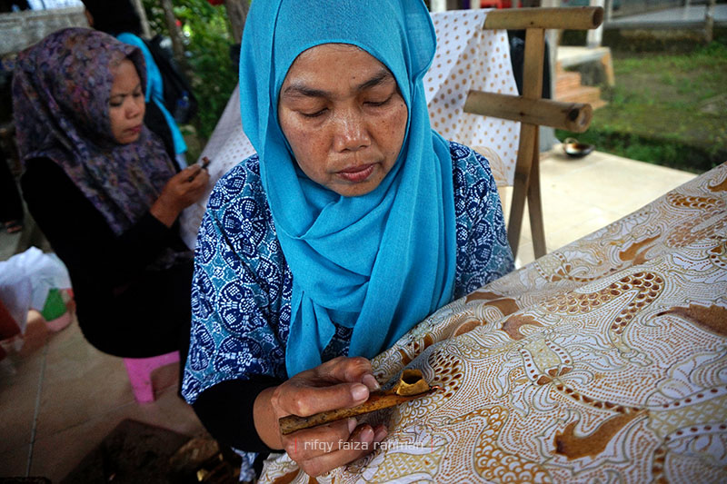 Nur Janah, seorang pengrajin, sedang mencanting di atas kain batik bermotif klasik