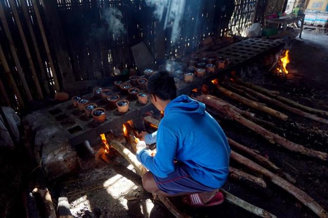 Syahrul mengecek kondisi api dan kayu bakar