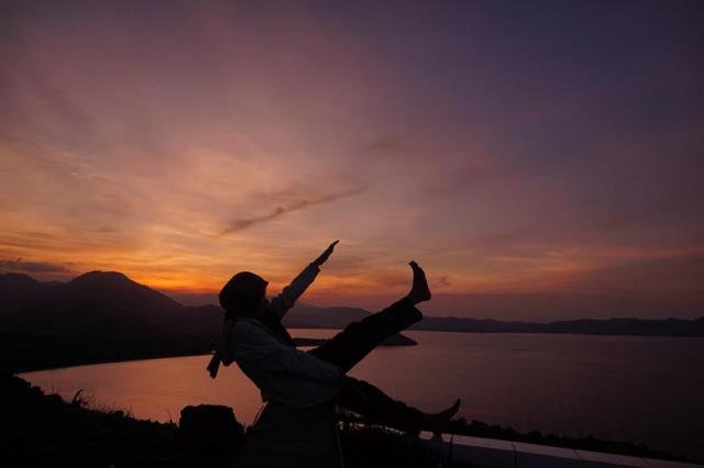 Siluet Nana berlatar senja yang mulai menggelap